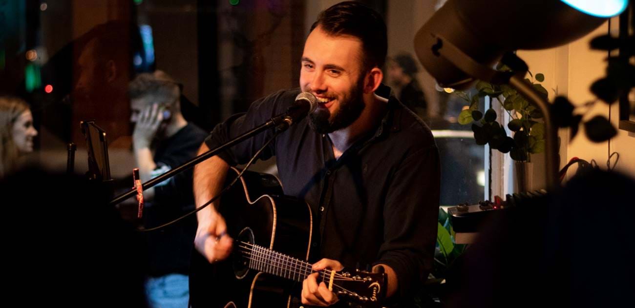 a male singer with guitar performing
